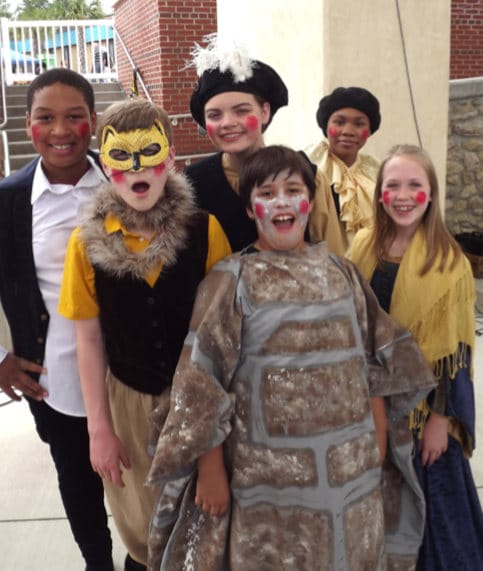 six members of The Bardlings pose in costume backstage at the Cascades Park amphitheater